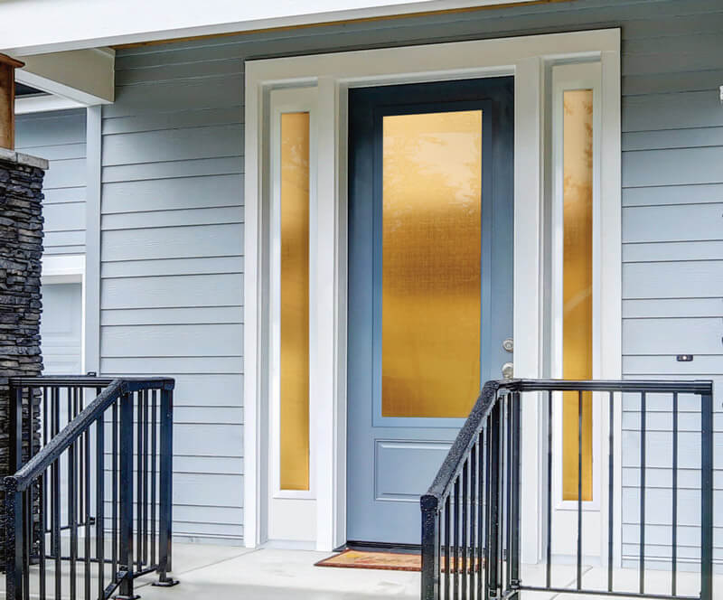 A Florida front door with a blue finish is flanked by tall, narrow frosted windows, set in a light gray house exterior. Black railings frame the steps leading up to the entrance.